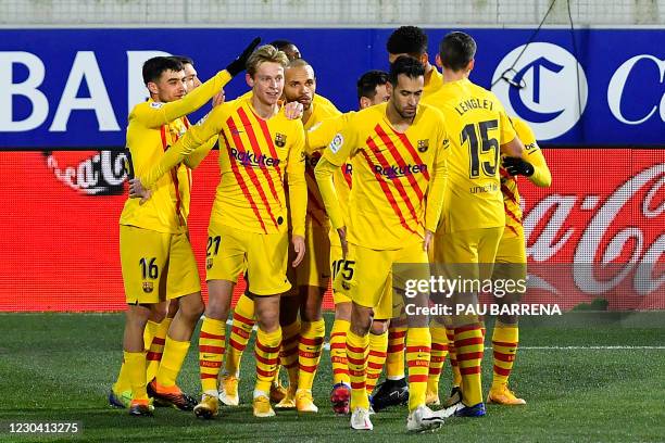 Barcelona's Dutch midfielder Frenkie De Jong celebrates with teammates after scoring a goal during the Spanish League football match between Huesca...