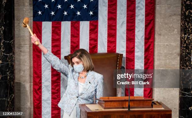 Speaker of the House Nancy Pelosi, D-Calif., holds the Speakers gavel in the air on the House floor in the Capitol after becoming Speaker of the...