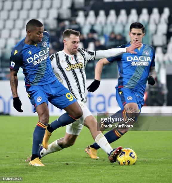 Aaron Ramsey of Juventus is tackled by Marvin Zeegelaar and Kevin Bonifazi of Udinese Calcio during the Serie A match between Juventus and Udinese...