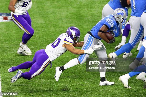 Detroit Lions running back Adrian Peterson is tackled by Minnesota Vikings outside linebacker Eric Wilson during the first half of an NFL football...