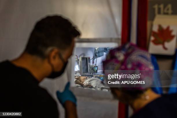 Medical Director of the Intensive Care Unit Dr. Thomas Yadegar and the Register Nurse Traveler Emily Kirk attend to a Covid-19 patient in an...