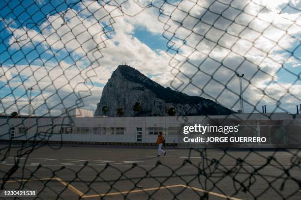 Woman walks past the Rock of Gibraltar as she crosses the border between Spain and Gibraltar in La Linea de la Concepcion on January 4, 2021. -...