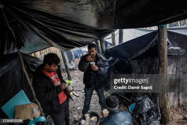 Migrants have a breakfast at a forest camp on January 4, 2021 where a group from Bangladesh found shelter near Velika Kladusa, Bosnia and...