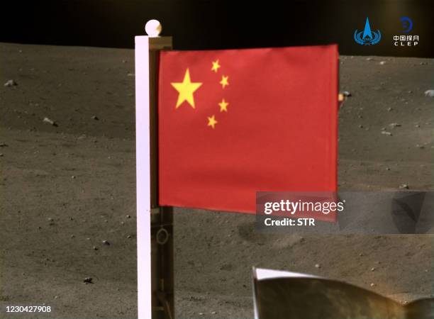 This picture taken and released on December 4 by the China National Space Administration via CNS shows a Chinese national flag unfurled from the...