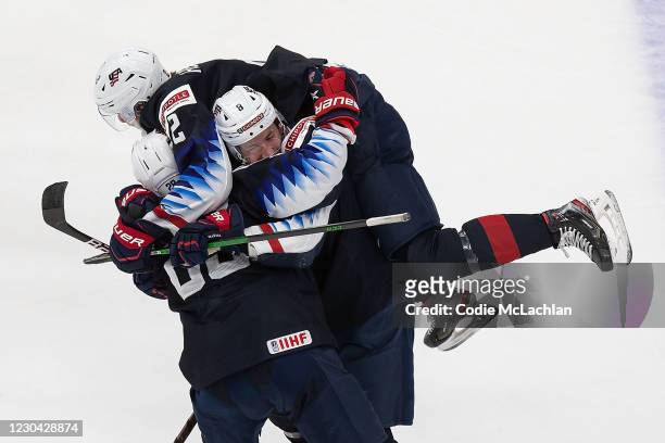 Arthur Kaliyev, Drew Helleson and Jake Sanderson of the United States celebrate the game-winning goal against Finland during the 2021 IIHF World...