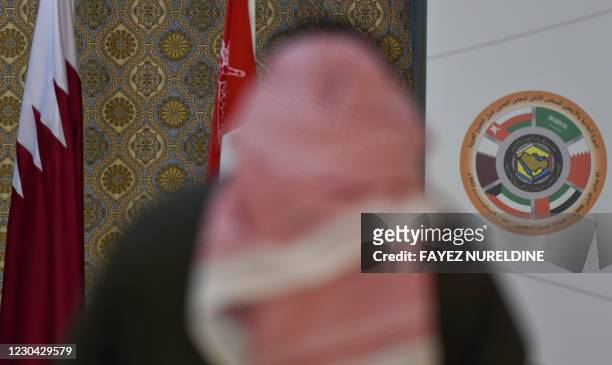 Saudi journalist is pictured in front of the logo of the Gulf Cooperation Council and the Qatari national flag at the media centre ahead of the 41st...