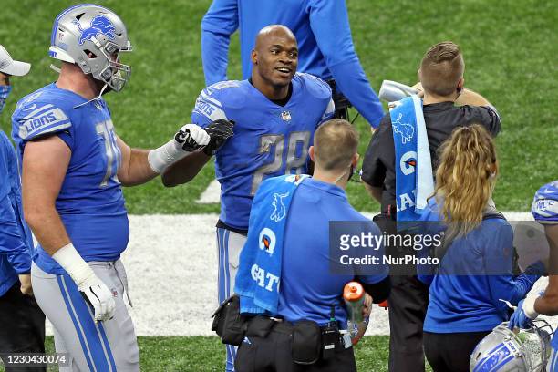 Detroit Lions running back Adrian Peterson is congratulated after making a touchdown during the second half of an NFL football game between the...
