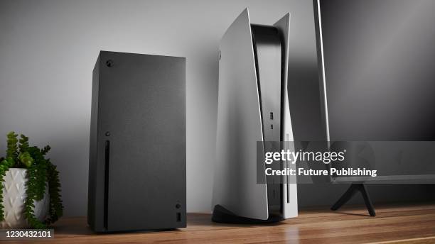 Living room with Microsoft Xbox Series X and Sony PlayStation 5 home video game consoles alongside a television and soundbar, taken on November 3,...