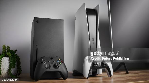 Living room with Microsoft Xbox Series X and Sony PlayStation 5 home video game consoles alongside a television and soundbar, taken on November 3,...