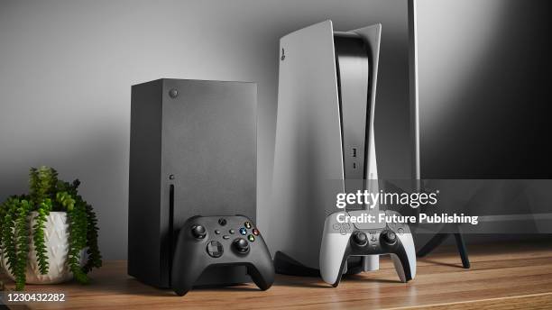 Living room with Microsoft Xbox Series X and Sony PlayStation 5 home video game consoles alongside a television and soundbar, taken on November 3,...