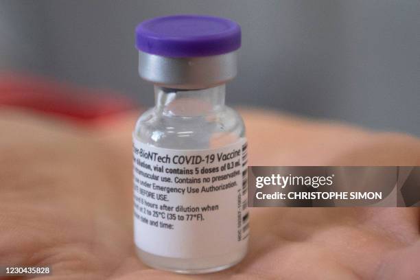 Health worker holds a vial containing the Pfizer-BioNTech Covid-19 vaccine at the Timone Hospital in Marseille, southeastern France, on January 5,...
