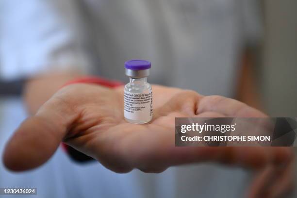 Health worker holds a vial containing the Pfizer-BioNTech Covid-19 vaccine at the Timone Hospital in Marseille, southeastern France, on January 5,...