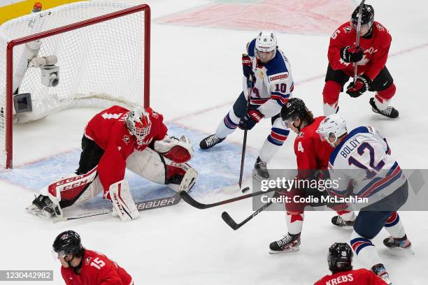 Bowen Byram and goaltender Devon Levi of Canada defend Matthew Beniers and Matthew Boldy of the United States during the 2021 IIHF World Junior...