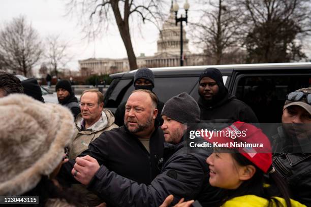 Flanked by personal security, Alex Jones leaves after speaking at a Stop the Steal rally in front of the Supreme Court on Tuesday, Jan. 5, 2021 in...