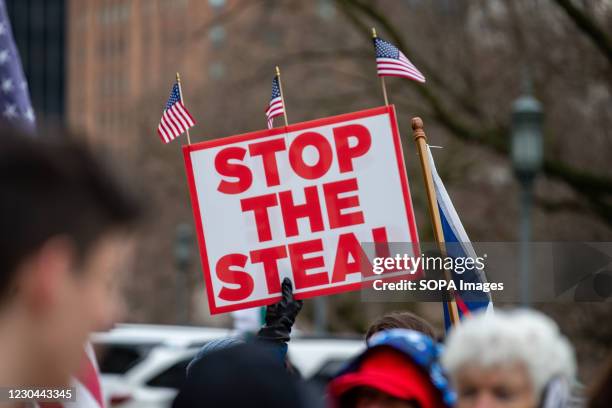 Protester holds a "stop the steal" placard during a pro-Trump demonstration. Supporters of President Donald Trump urged legislators to decertify the...