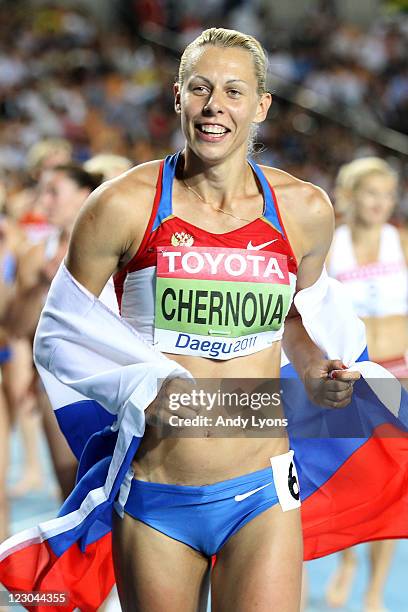 Tatyana Chernova of Russia celebrates with her country's flag after claiming gold in the women's heptathlon during day four of the 13th IAAF World...