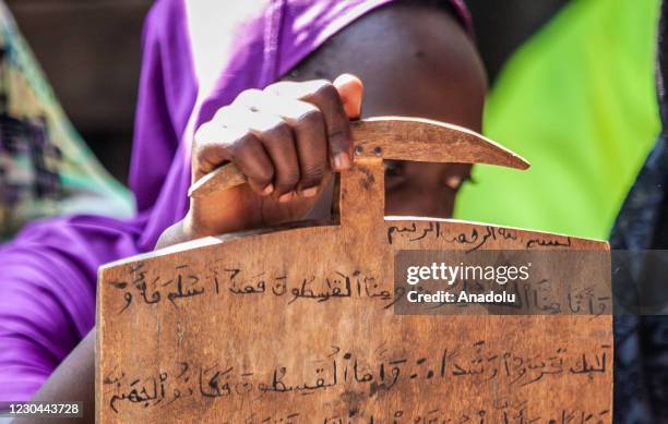 Children are seen at a class as Ibrahim Yawesse teaches the holy book Quran to children on wooden boards after he transformed his home into a...
