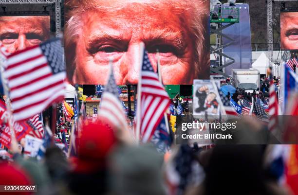 An image of President Donald Trump appears on video screens before his speech to supporters from the Ellipse at the White House in Washington on...