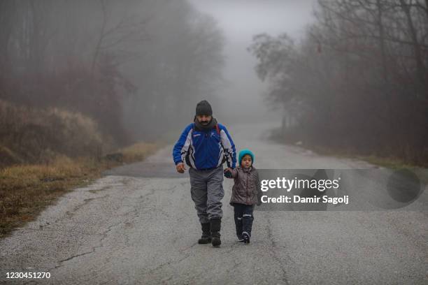 Members of a migrant family from Afghanistan approach Croatia's border from Bosnian side in an attempt to cross into EU by foot, known as "The Game"...