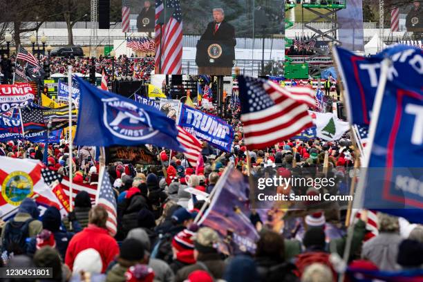 President Donald Trump is seen on a screen as his supporters cheer during a rally on the National Mall on January 6, 2021 in Washington, DC. Trump...