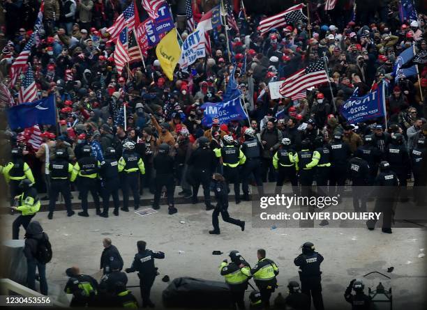 Police hold back supporters of US President Donald Trump as they gather outside the US Capitol's Rotunda on January 6 in Washington, DC. -...