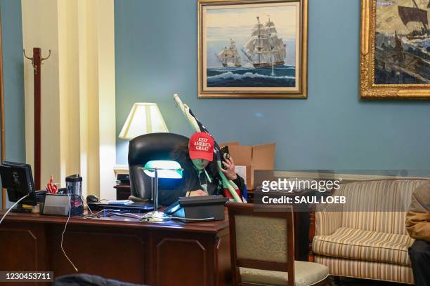 Supporter of US President Donald Trump sits inside the office of Speaker of the House Nancy Pelosi as he protest inside the US Capitol in Washington,...
