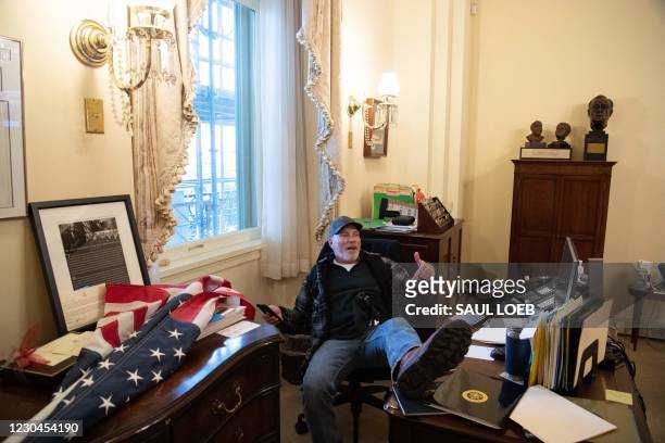 Richard Barnett, a supporter of US President Donald Trump sits inside the office of US Speaker of the House Nancy Pelosi as he protest inside the US...