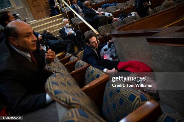 Rep. Jason Crow, D-Colo., comforts Rep. Susan Wild, D-Pa., while taking cover as protesters disrupt the joint session of Congress to certify the...
