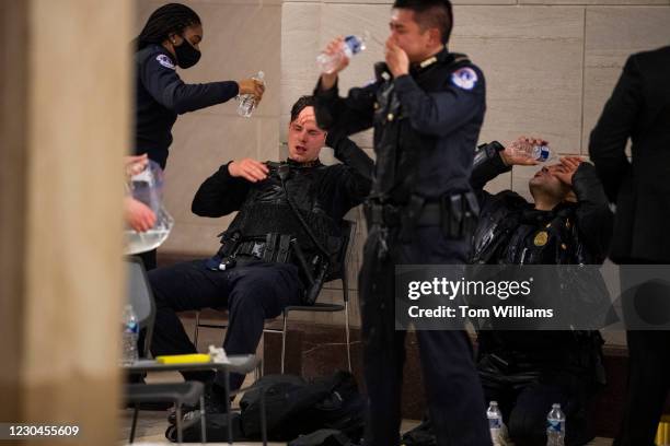 Capitol Police officers receive medical treatment after clashes with protesters attempting to disrupt the joint session of Congress to certify the...