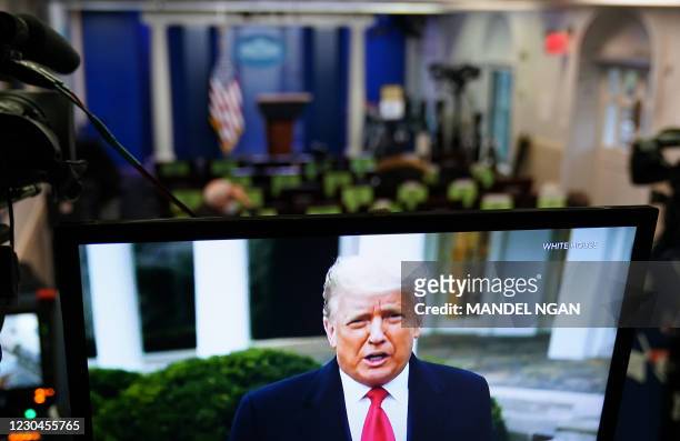 President Donald Trump is seen on TV from a video message released on Twitter addressing rioter at the US Capitol, in the Brady Briefing Room at the...