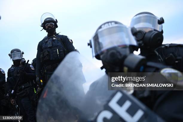 Police watch supporters of US President Donald Trump at the US Capitol in Washington, DC, on January 6, 2021. - Demonstrators breeched security and...