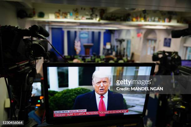 President Donald Trump is seen on TV from a video message released on Twitter, seen in an empty Brady Briefing Room at the White House in Washington,...