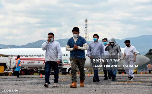 Guatemalan migrants deported from the United States, walk upon their arrival at the Air Force Base in Guatemala City on January 6, 2021. - During...