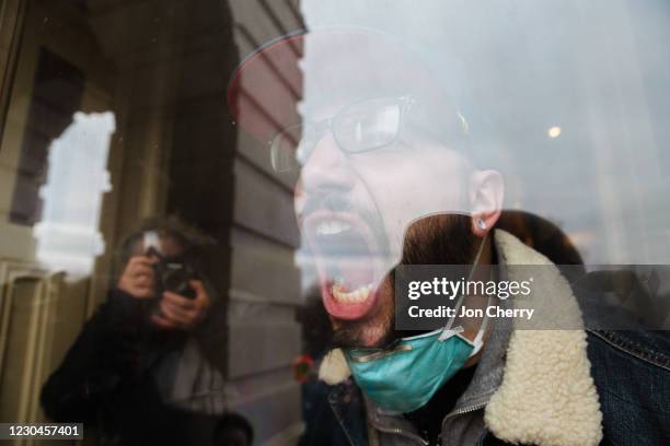 Member of a pro-Trump mob screams out at the crowd from the inside of the Capitol Building after breaking into it on January 6, 2021 in Washington,...