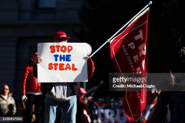 Donald Trump supporter holds a Stop the Steal sign while gathering on the steps of the Colorado State Capitol to protest the election on January 6,...
