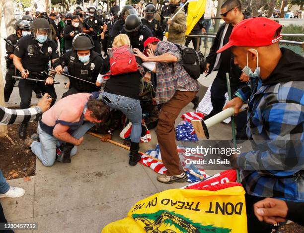 Pro-Trump demonstrators fight with anti demonstrators after a pro-trump rally outside Los Angeles City Hall Wednesday, Jan. 6, 2021. Demonstrators,...