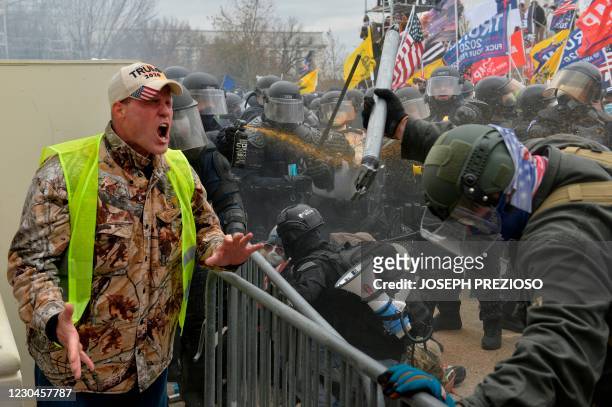 Trump supporter screams towards police and security forces as demonstrators storm the US Capitol in Washington D.C on January 6, 2021. - Donald...