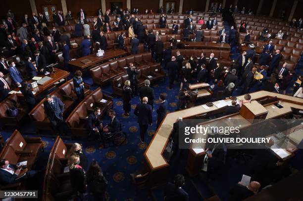 Members of the Congress prepare to evacuate as the joint session of Congress scheduled to count the electoral votes for President is interrupted by...
