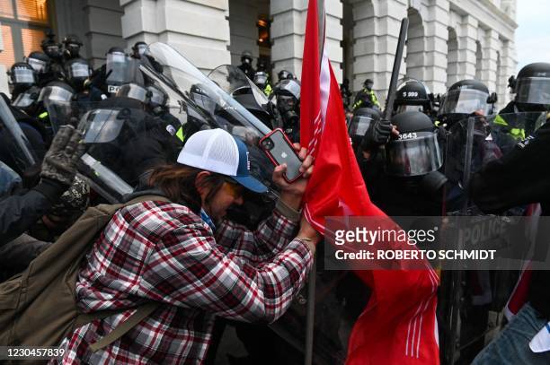 Riot police push back a crowd of supporters of US President Donald Trump after they stormed the Capitol building on January 6, 2021 in Washington,...