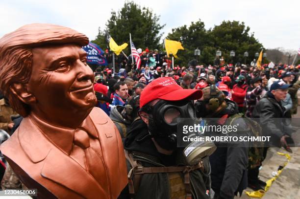 Supporter of US President Donald Trump wears a gas mask and holds a bust of him after he and hundreds of others stormed stormed the Capitol building...