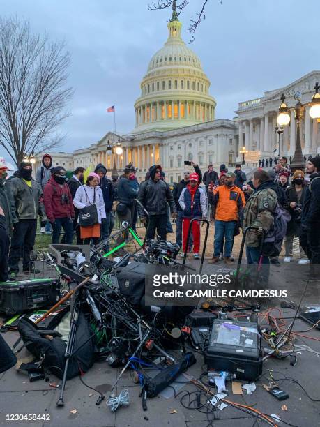 People stand around media equipment destroyed by Trump supporters outside the US Capitol in Washington DC on January 6, 2021. - Donald Trump's...