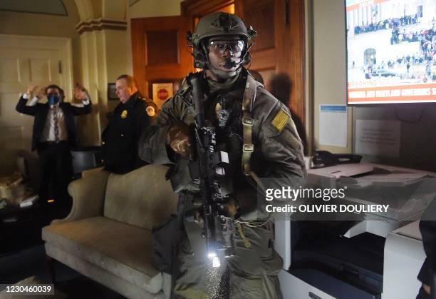 Congress staffers hold their hands up while Capitol Police Swat teams check everyone in the room as they secure the floor of Trump suporters in...