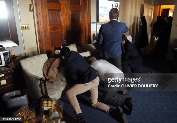 Congress staffers barricade themselves after Trump supporters stormed inside the US Capitol in Washington, DC on January 6, 2021. - Donald Trump's...