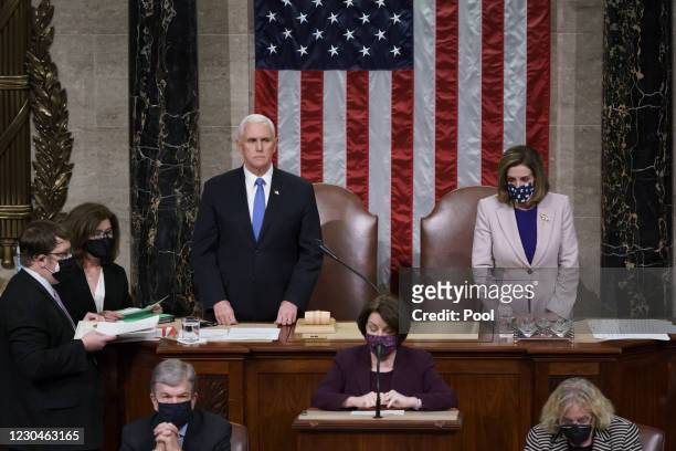 Vice President Mike Pence and Speaker of the House Nancy Pelosi, D-Calif., read the final certification of Electoral College votes cast in November's...