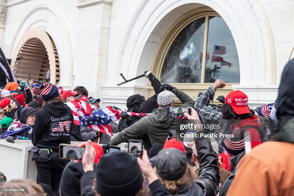 Pro-Trump protesters break windows of the Capitol building.
