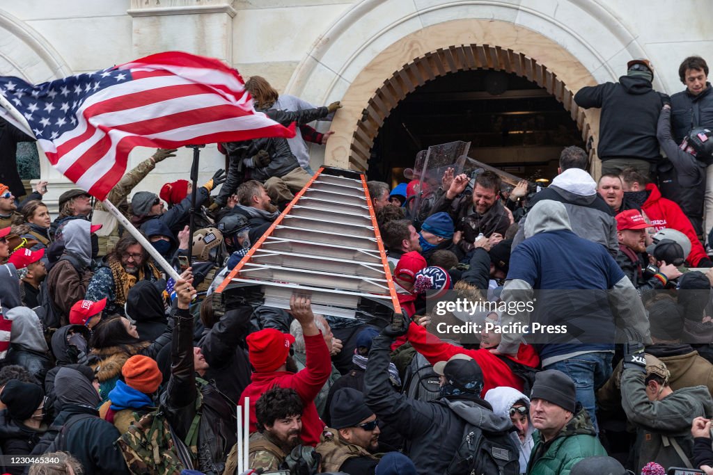 Rioters clash with police using big ladder trying to enter...