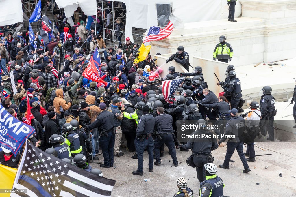 Pro-Trump protesters and police clash on top of the Capitol...