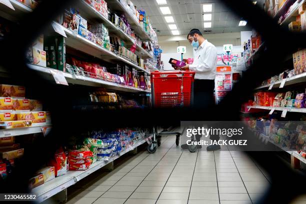 An Israeli man, mask-clad due to the COVID-19 pandemic, shops for food supplies at a supermarket in the Israeli city of Bnei Brak on January 7 as the...