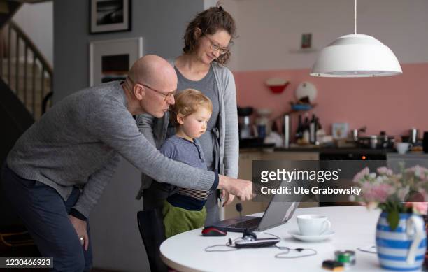Bonn, Germany In this photo illustration a toddler and its parents are looking at a screen of a laptop on January 07, 2021 in Bonn, Germany.