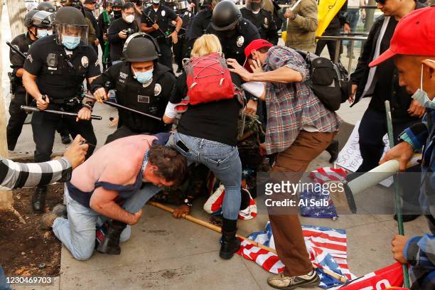 Pro-Trump demonstrators fight with anti demonstrators after a pro-trump rally outside Los Angeles City Hall Wednesday, Jan. 6, 2021. Demonstrators,...